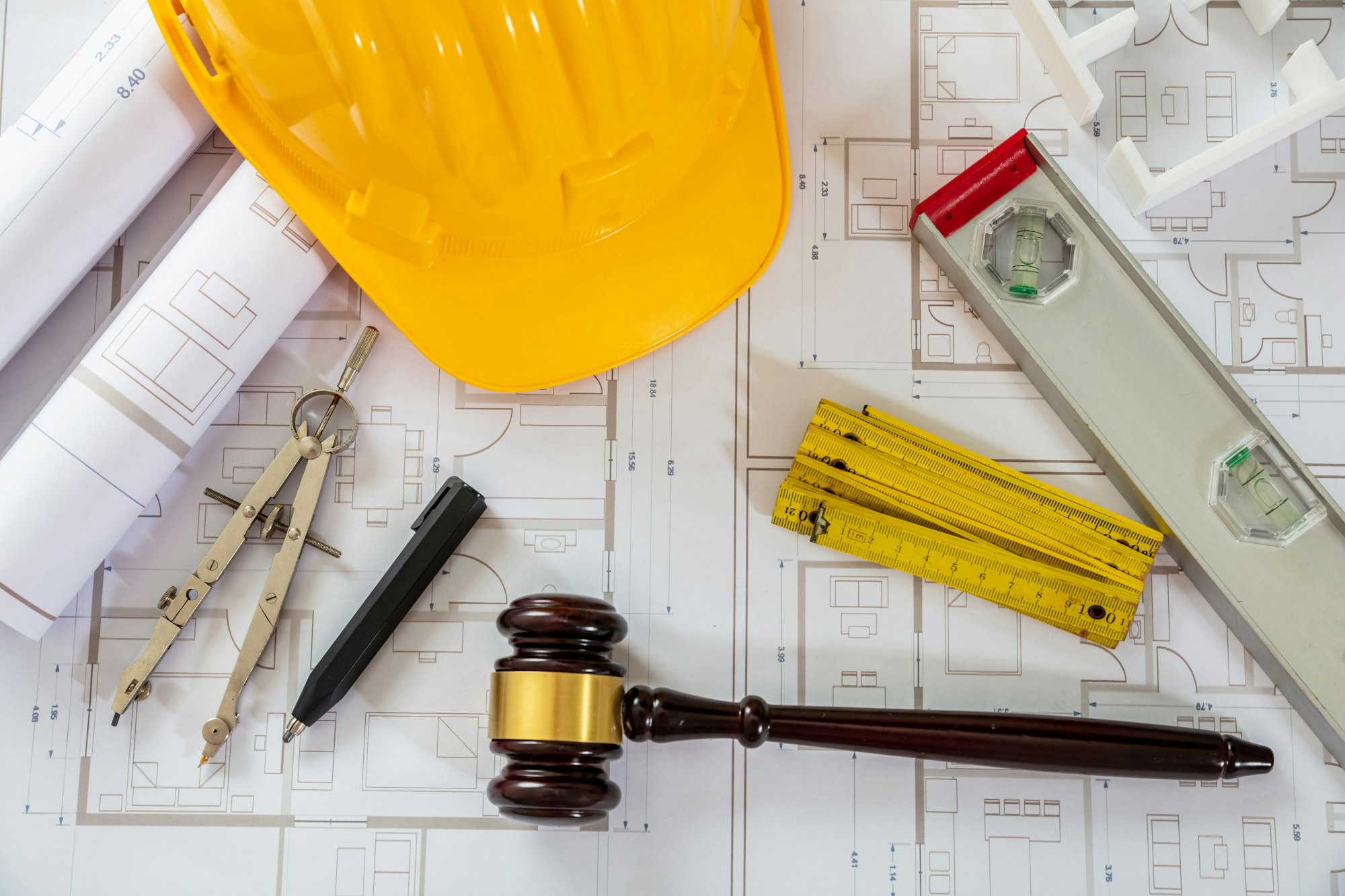 Construction and Labor law flat lay. Judge gavel and design tools on building blueprint